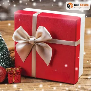 Custom printed Christmas candy boxes by Box Squire, featuring a festive red and green design with gold foil accents, filled with assorted holiday chocolates and treats.